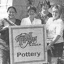 Titusville Art Leaguemembers hold sign.