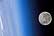 A full moon is visible in this view above Earth's horizon and airglow.