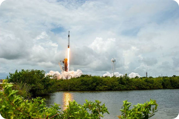 The SpaceX Falcon 9 rocket carrying the Dragon cargo capsule lifts off.